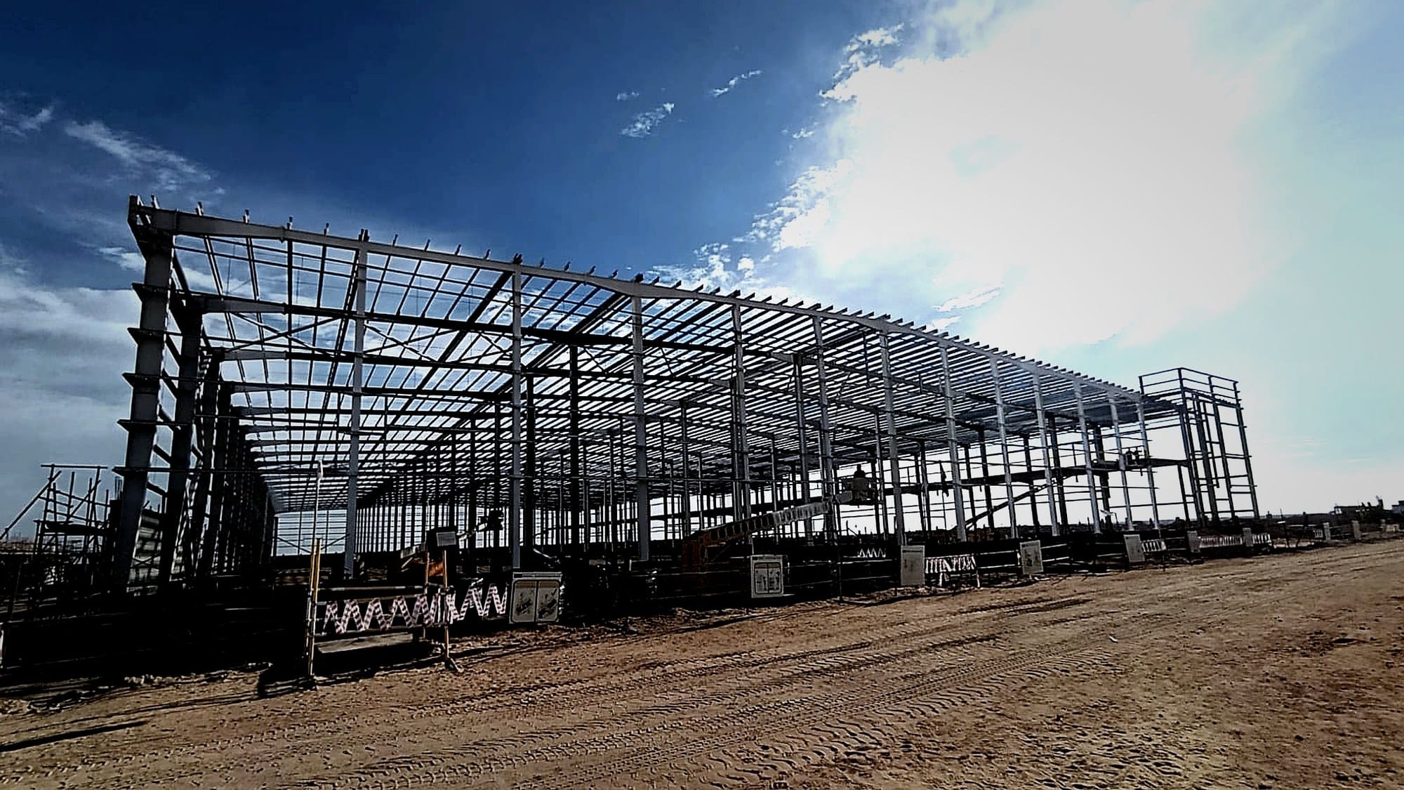Side view of the full medical warehouse steel frame under a dramatic sky